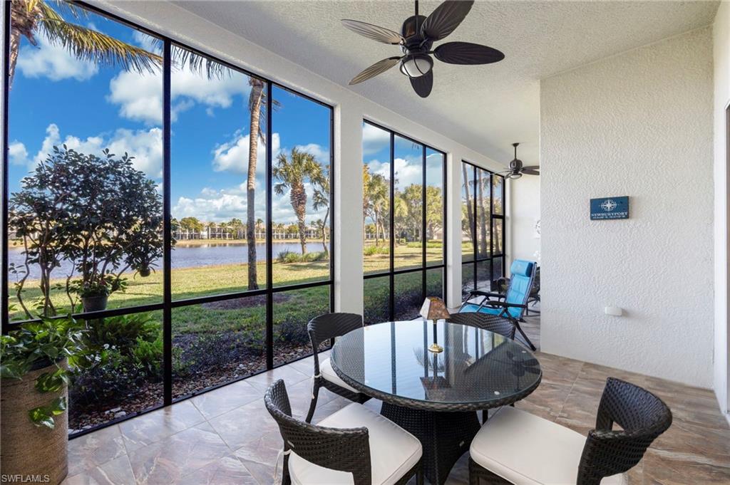 9288 Grassi Way, Unit 102 Naples, FL 34114 - Photo 24 of 37 Lanai featuring a textured wall, a water view, a ceiling fan, outdoor dining area, and a textured ceiling and tiled floor