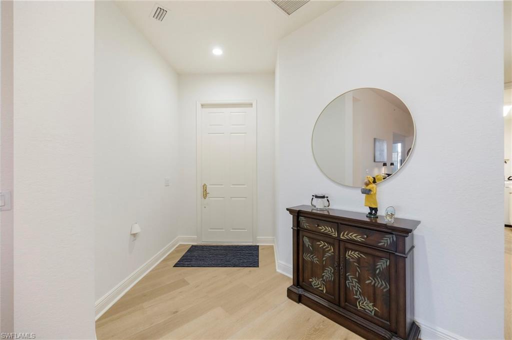 9288 Grassi Way, Unit 102 Naples, FL 34114 - Photo 4 of 37 a room with a mirror and a sink