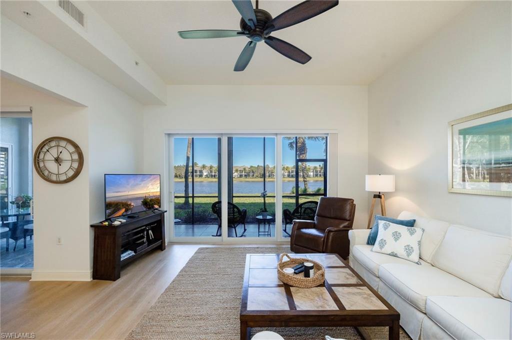9288 Grassi Way, Unit 102 Naples, FL 34114 - Photo 5 of 37 a living room with furniture a window and a clock