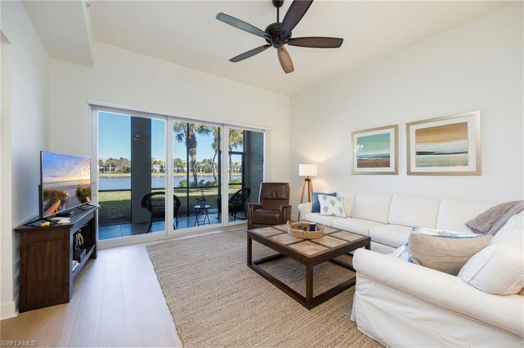 9288 Grassi Way, Unit 102 Naples, FL 34114 - Photo 8 of 37 a living room with furniture ceiling fan and a rug
