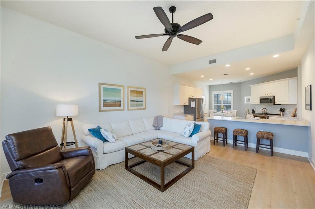 9288 Grassi Way, Unit 102 Naples, FL 34114 - Photo 9 of 37 a living room with furniture and a view of kitchen