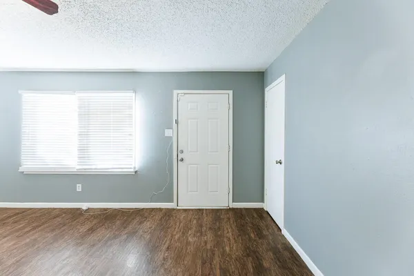 a view of an empty room with a window and a ceiling fan