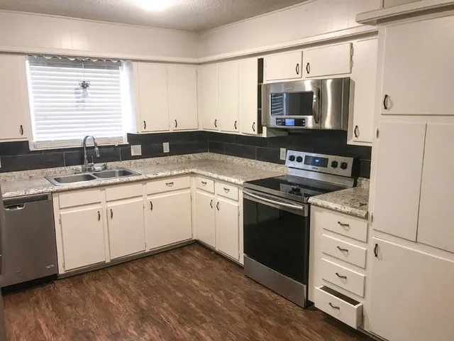 a kitchen with a stove microwave and sink