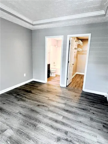 a view of empty room with wooden floor and window