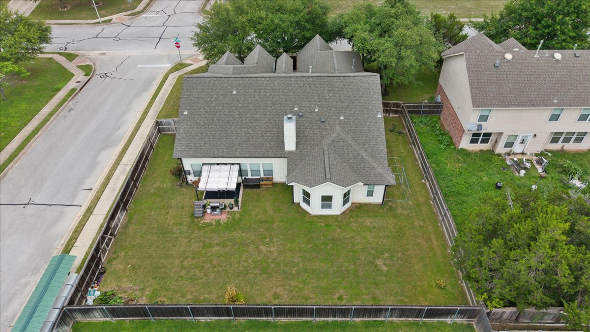 2501 Aspen Meadow Road Leander, TX 78641 - Photo 28 of 30 Expansive green lawn with a white single-story exterior, featuring a covered patio, a bay window, and a gray shingle roof