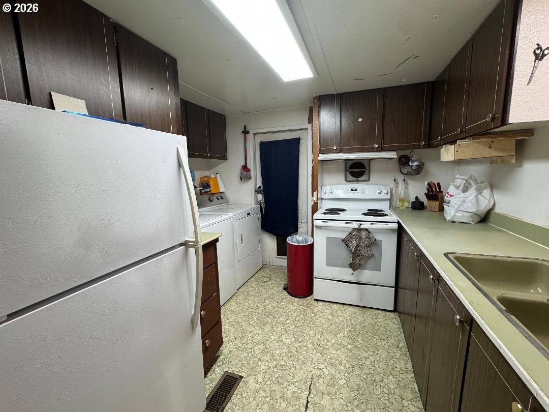 5000 Northeast Stephens Street, Unit 2 Roseburg, OR 97470 - Photo 11 of 23 a kitchen with a refrigerator sink and wooden cabinets