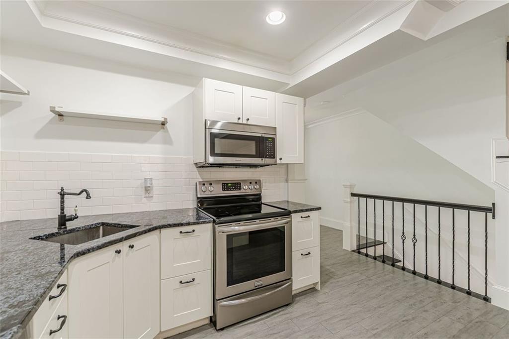 320 Alberta Terrace Northeast, Unit 3 Atlanta, GA 30305 - Photo 19 of 54 a kitchen with granite countertop white cabinets stainless steel appliances and a counter space