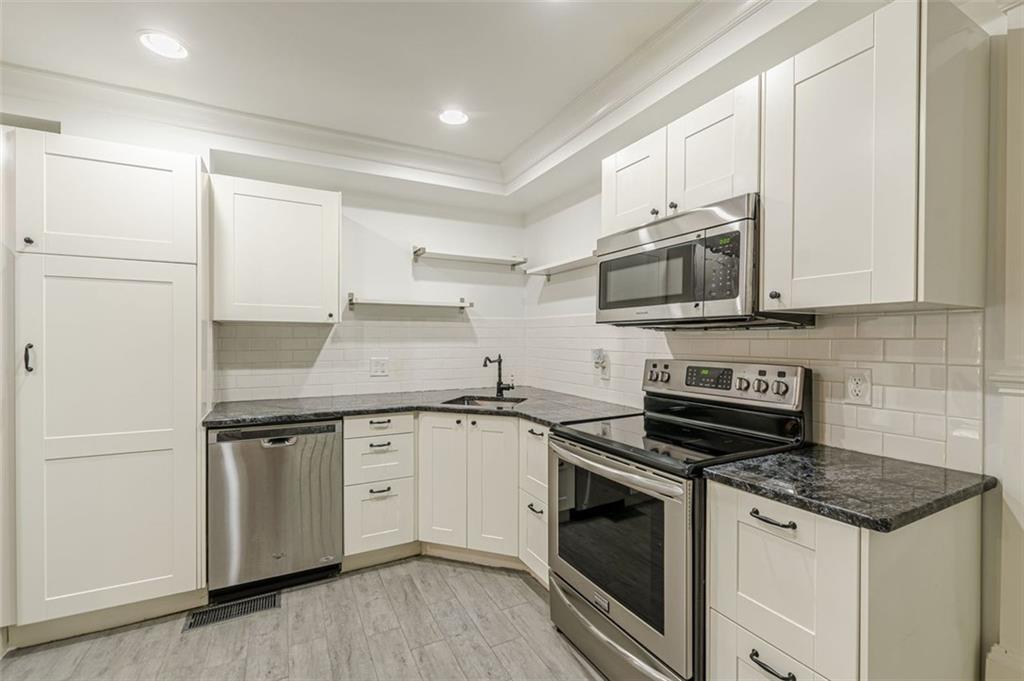 320 Alberta Terrace Northeast, Unit 3 Atlanta, GA 30305 - Photo 22 of 54 a kitchen with stainless steel appliances granite countertop a stove and a microwave
