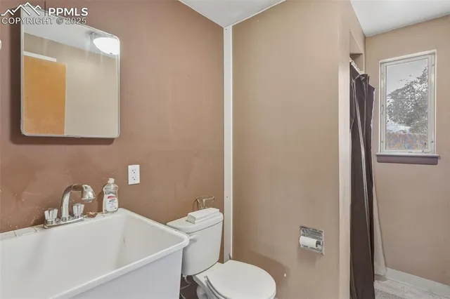 a bathroom with a toilet a sink a mirror and bathtub