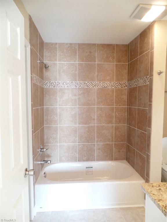 1939 Bloomtown Road East Bend, NC 27018 - Photo 23 of 26 Master tub/shower with tiled surround with inlaid mosaic accents.