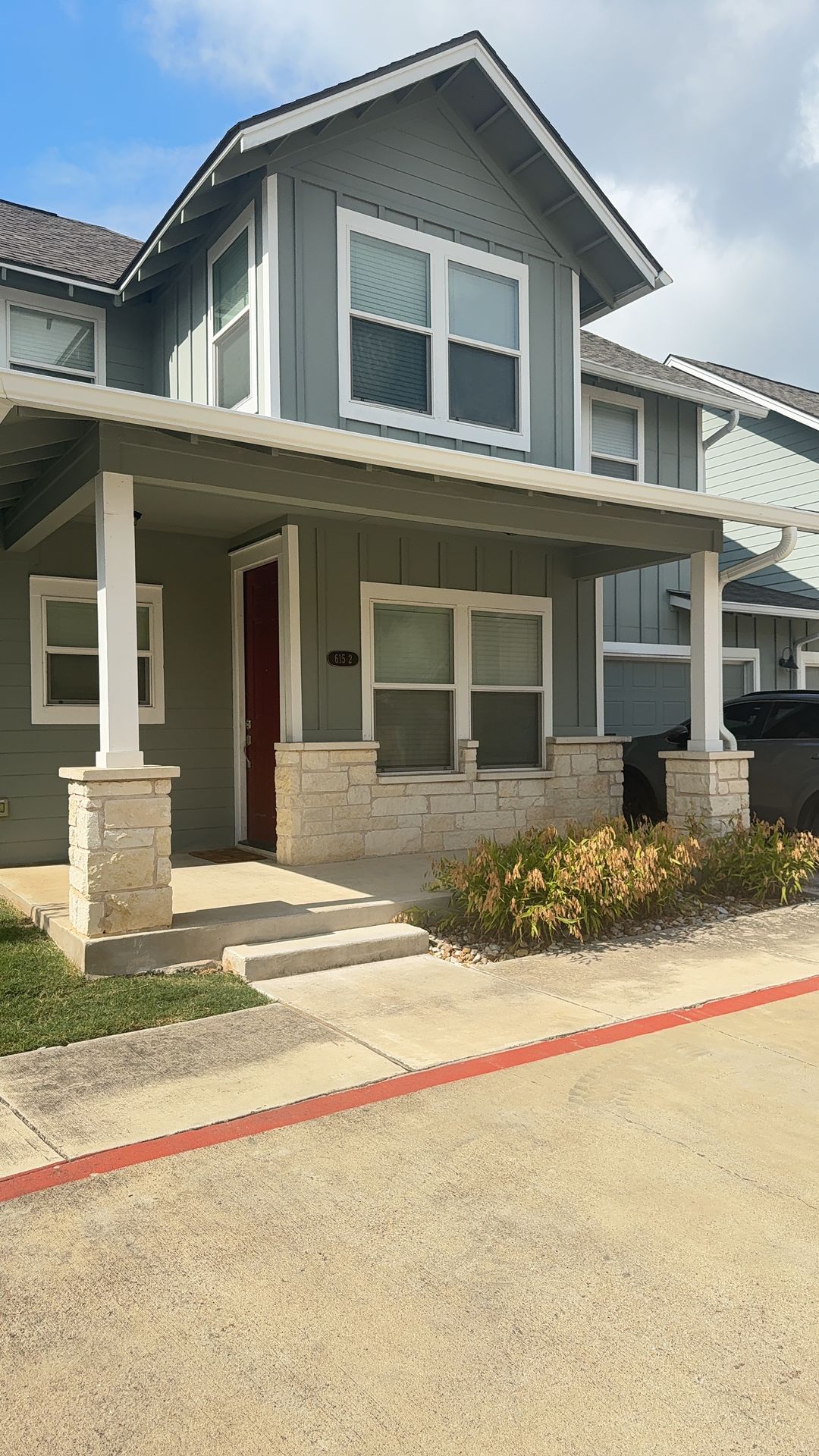 615 Spring Street, Unit 2 Round Rock, TX 78664 - Photo 1 of 2 Welcoming front porch entry showcases charming stone column bases under modern board and batten siding.