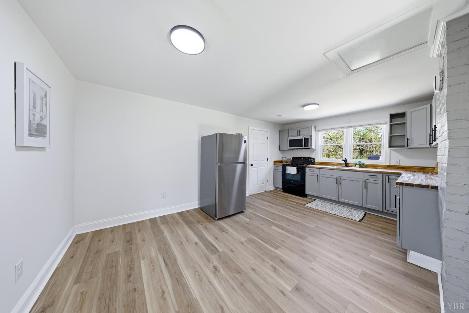 1410 Lynch Road Altavista, VA 24517 - Photo 7 of 34 a large kitchen with a wooden floor and stainless steel appliances
