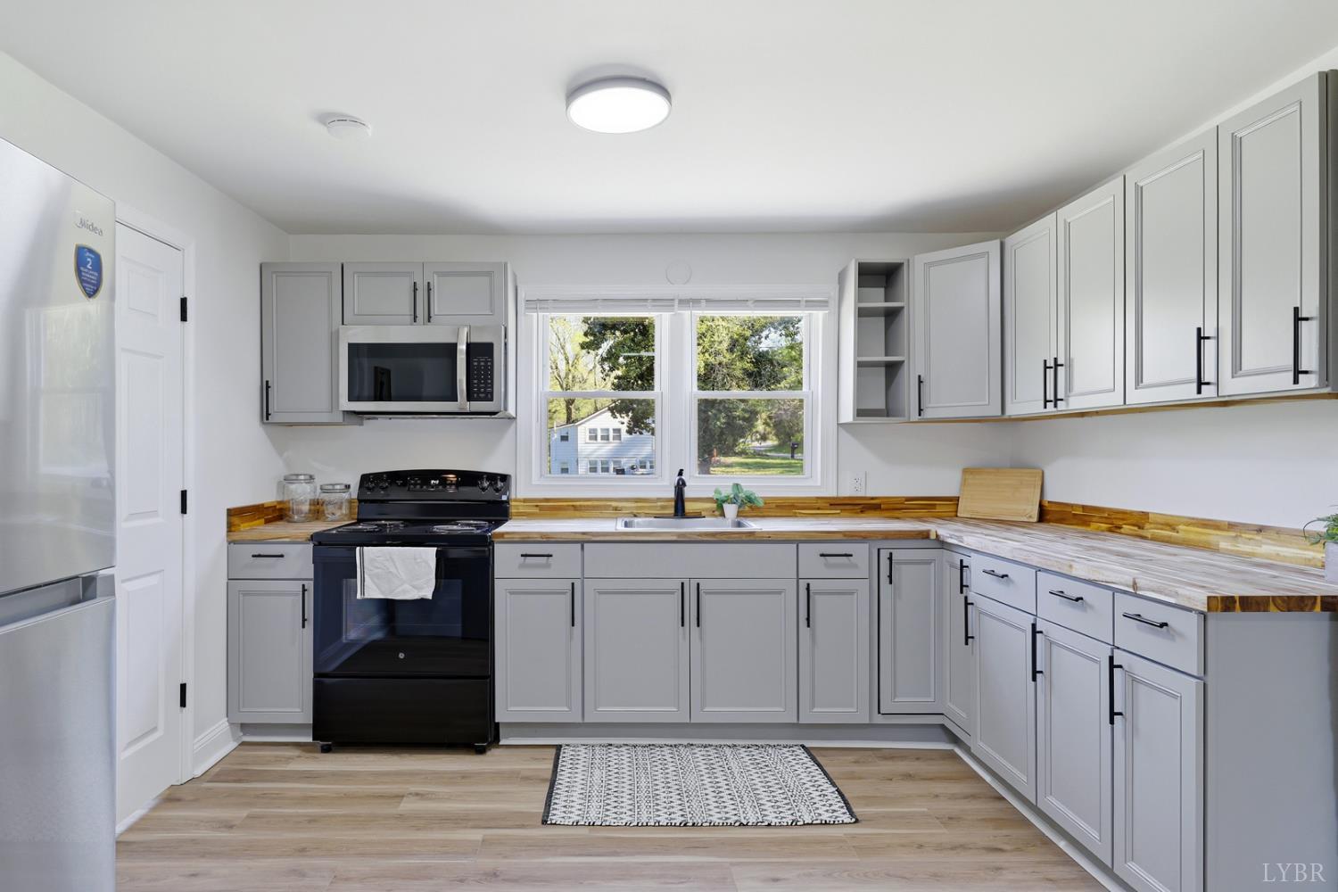 1410 Lynch Road Altavista, VA 24517 - Photo 9 of 34 a kitchen with a sink window and cabinets