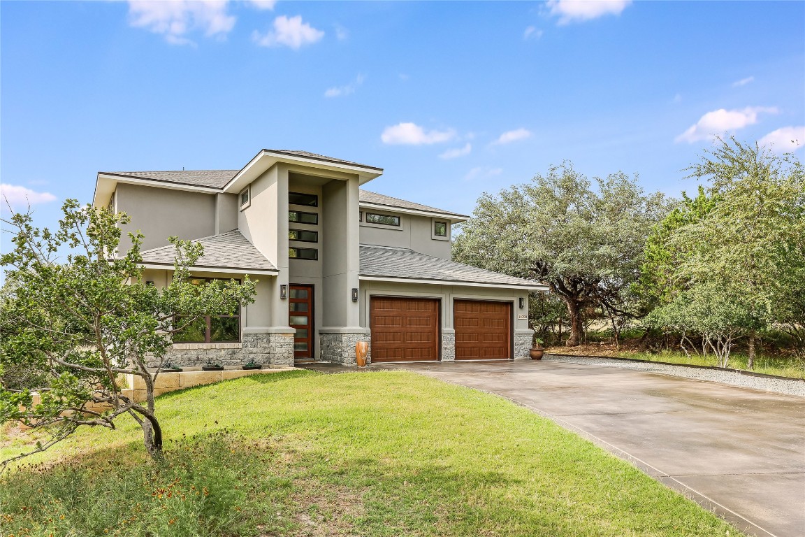 18700 Venture Drive Point Venture, TX 78645 - Photo 1 of 1 a front view of house with yard and trees in the background