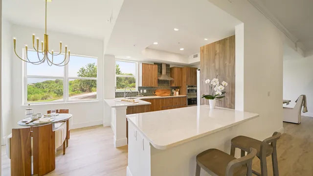 a large kitchen with granite countertop a sink and cabinets