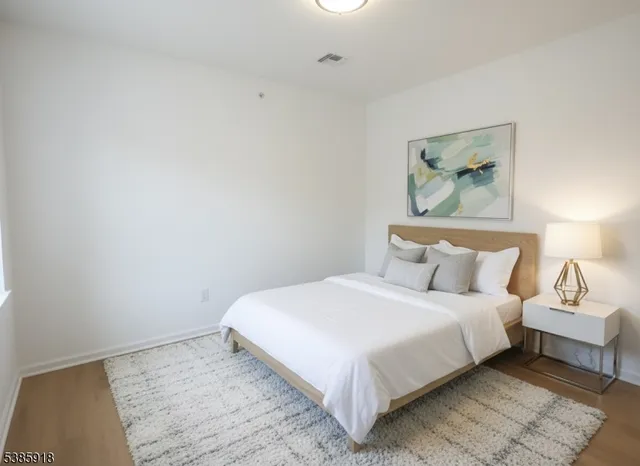 a bedroom with a bed and a painting on the wall