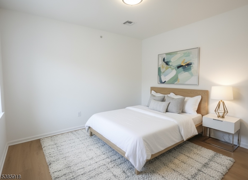 588 Springfield Avenue, Unit 1 Berkeley Heights, NJ 07922 - Photo 11 of 12 a bedroom with a bed and a painting on the wall