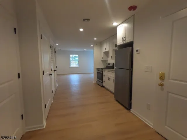 a view of a hallway with stainless steel appliances