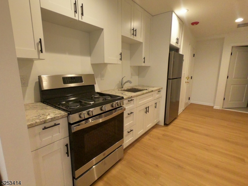 588 Springfield Avenue, Unit 1 Berkeley Heights, NJ 07922 - Photo 3 of 12 a kitchen with stainless steel appliances a stove a refrigerator and cabinets