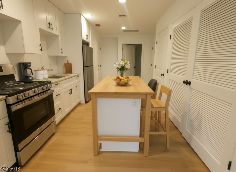 588 Springfield Avenue, Unit 1 Berkeley Heights, NJ 07922 - Photo 6 of 12 a kitchen with kitchen island a stove a sink and a refrigerator