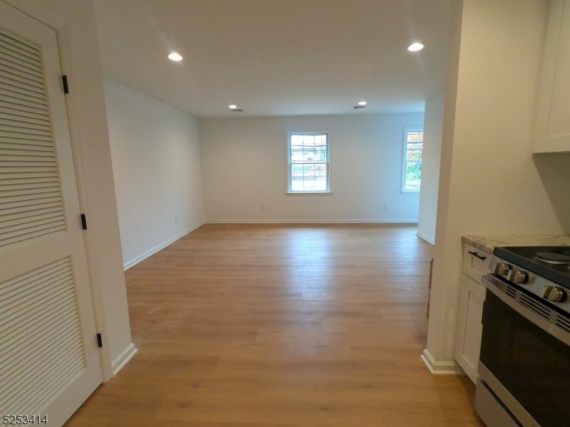 588 Springfield Avenue, Unit 1 Berkeley Heights, NJ 07922 - Photo 7 of 12 an empty room with wooden floor and a fireplace