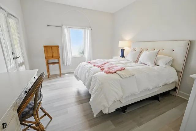 a bedroom with bed and wooden floor