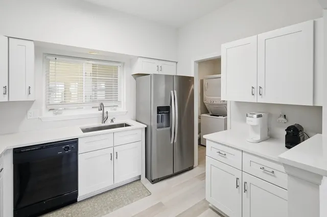 a kitchen with a refrigerator sink and cabinets