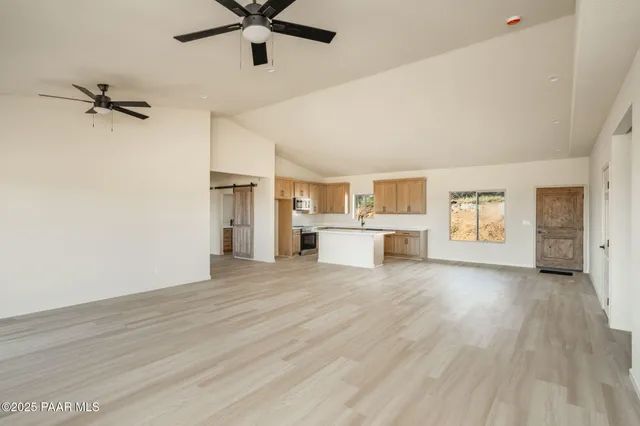 a view of a kitchen with a sink cabinet a ceiling fan and wooden floor