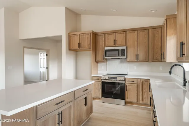 a kitchen with stainless steel appliances granite countertop a stove a sink and a microwave