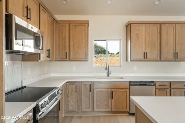 a kitchen with a sink cabinets and window