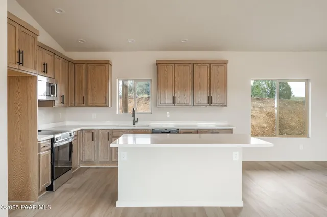 a kitchen with stainless steel appliances granite countertop a stove a sink and a refrigerator