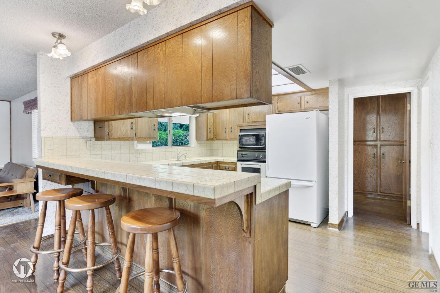 Undisclosed Address Bakersfield, CA 93308 - Photo 13 of 45 a kitchen with stainless steel appliances a refrigerator and a wooden floor