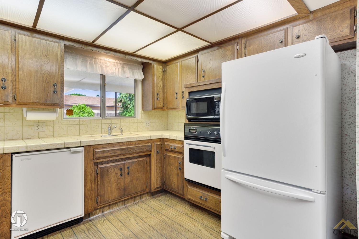 Undisclosed Address Bakersfield, CA 93308 - Photo 14 of 45 a kitchen with stainless steel appliances a sink cabinets and wooden floor