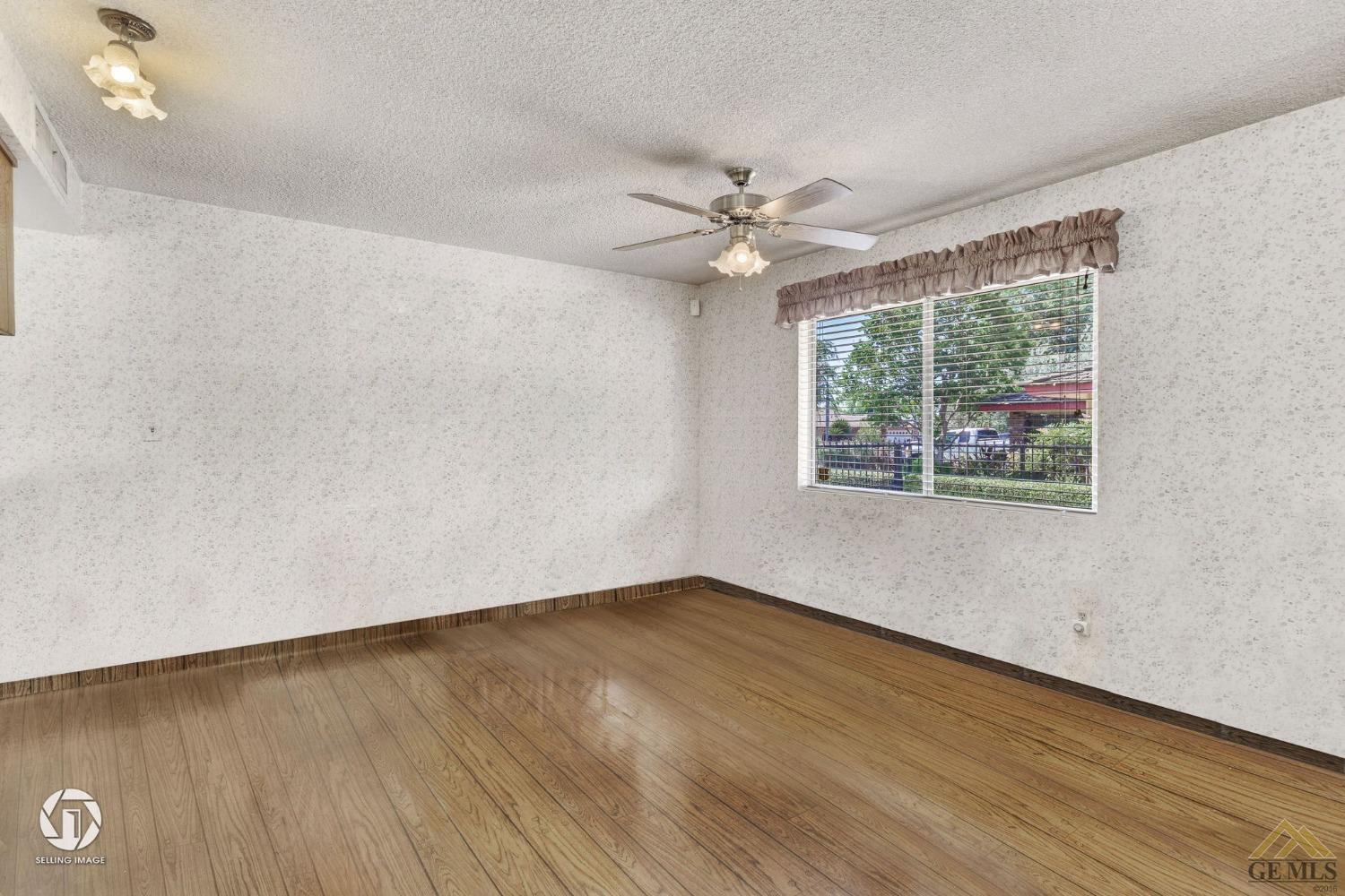 Undisclosed Address Bakersfield, CA 93308 - Photo 17 of 45 an empty room with wooden floor and windows