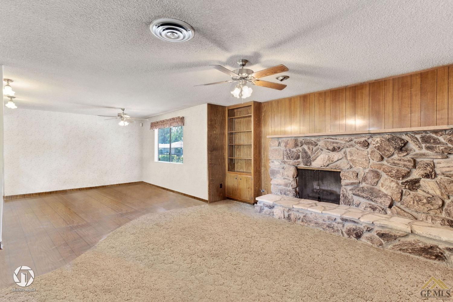 Undisclosed Address Bakersfield, CA 93308 - Photo 19 of 45 an empty room with fireplace and fan