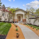 a front view of a house with a garden and plants