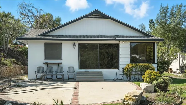 a view of a house with backyard and sitting area