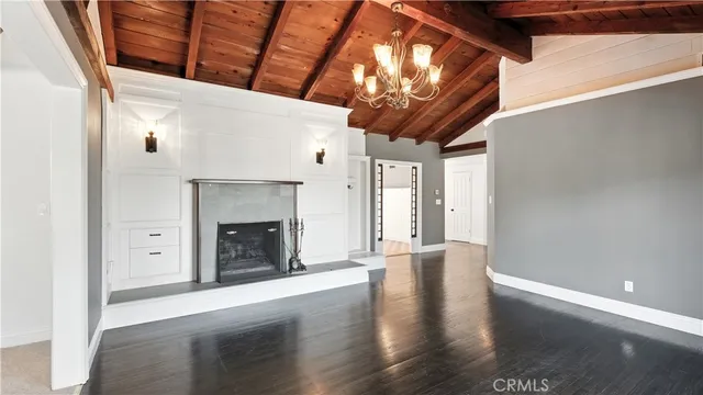 a view of a livingroom with wooden floor and a fireplace