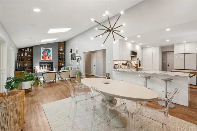a kitchen with stainless steel appliances kitchen island granite countertop a table chairs and a refrigerator