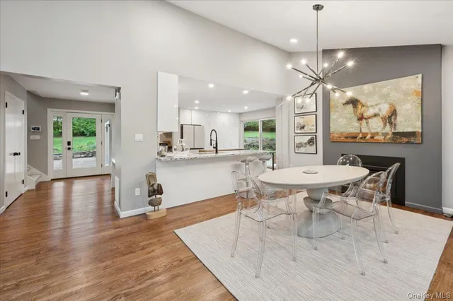 a open kitchen with stainless steel appliances kitchen island granite countertop a table chairs and a refrigerator