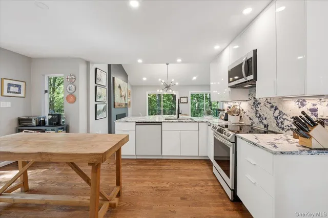 a kitchen with stainless steel appliances granite countertop a stove top oven a sink dishwasher and a refrigerator