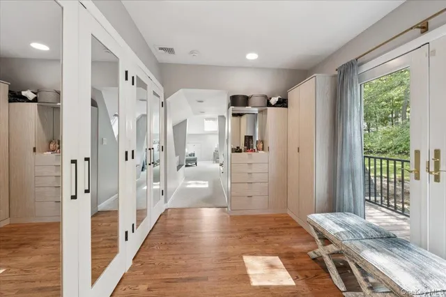 a view of a hallway with wooden floor and windows