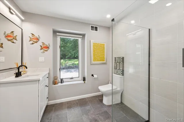 a bathroom with a sink toilet and a window