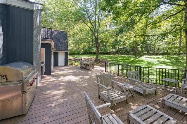 a view of a patio with table and chairs potted plants and large tree