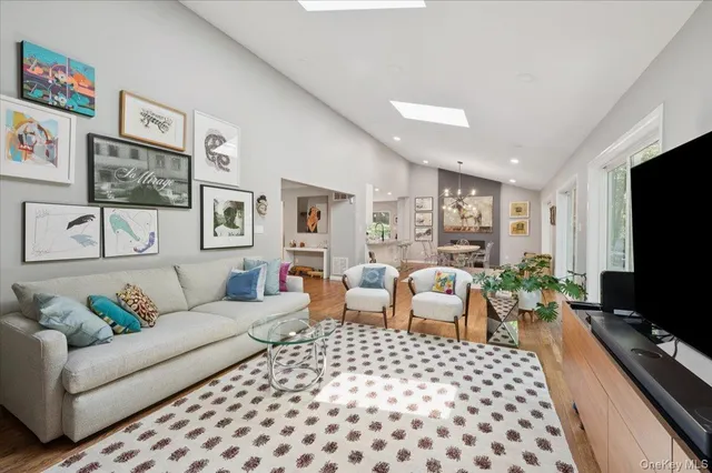 a living room with furniture a flat screen tv and a table