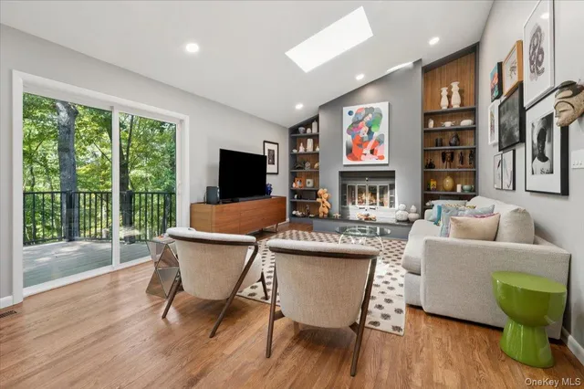 a living room with furniture a flat screen tv and a large window