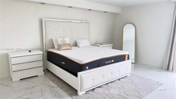 a living room with a bed and a mirror