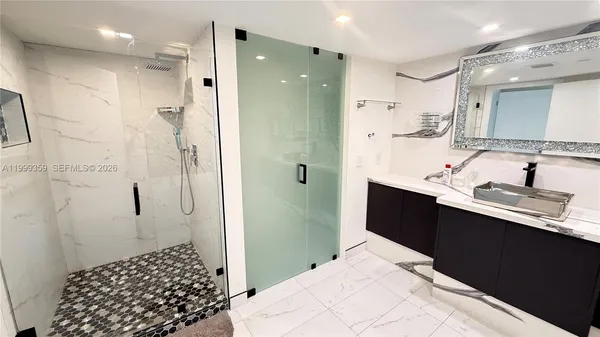 a bathroom with a double vanity sink a shower and a mirror