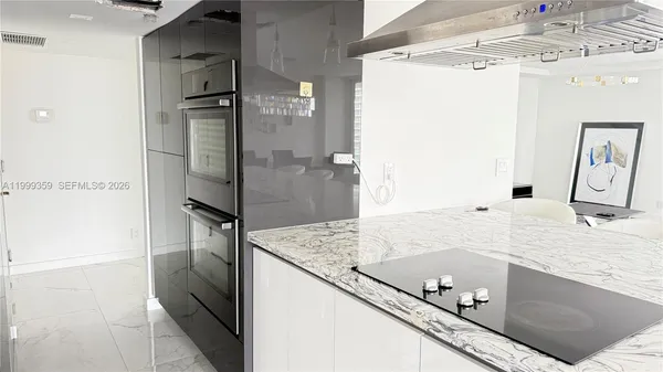 a bathroom with a granite countertop sink a mirror and shower