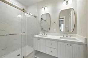 a bathroom with double vanity sinks and a mirror